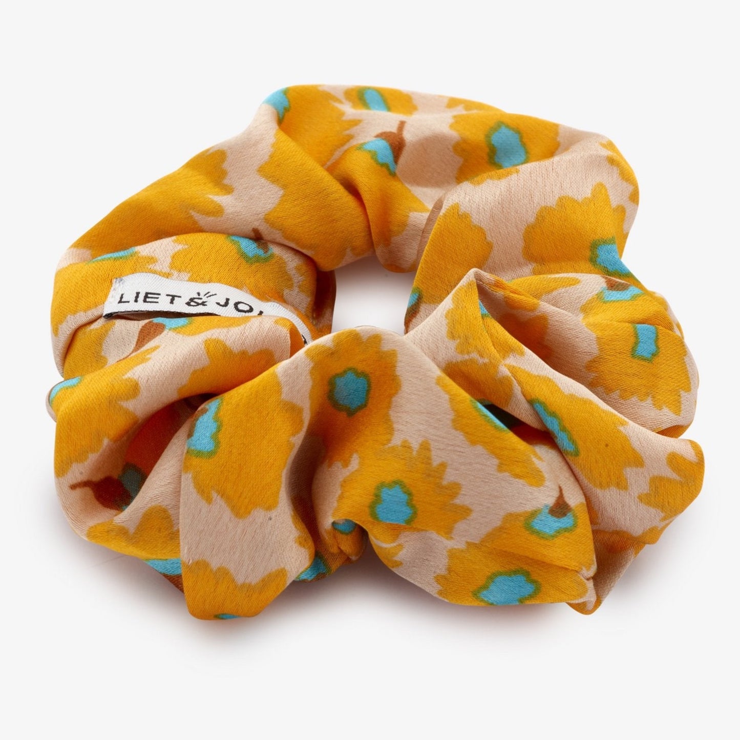 Voeg wat zomer toe aan je haar, met deze vrolijke scrunchie van Liet&Joliet    De scrunchie is gemaakt van polyester en heeft een diameter van ongeveer 13cm.  De stof heeft een satijn effect in een oranje bloemenprint.